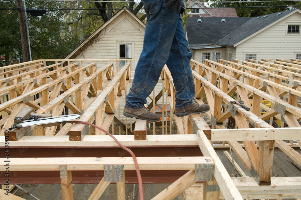 Worker framing a building on a construction site; Lincoln, Nebraska, United States of America Worker framing a building on a construction site; Lincoln, Nebraska, United States of America