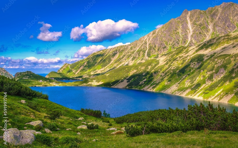 Beautiful blue lake in polish mountains. Picturesque view stretches over lakes in the Five Pond Valley and mountain ridge in Tatra mountains, Poland.