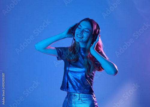 a happy woman listens to music with headphones happily smiling