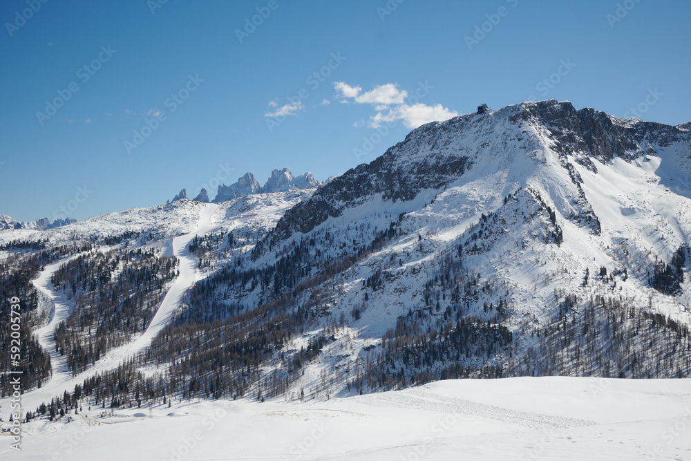 Góry zimą, narciarze na stokach, ferie zimowe na nartach, panoramy ośnieżonych szczytów. Mróz.