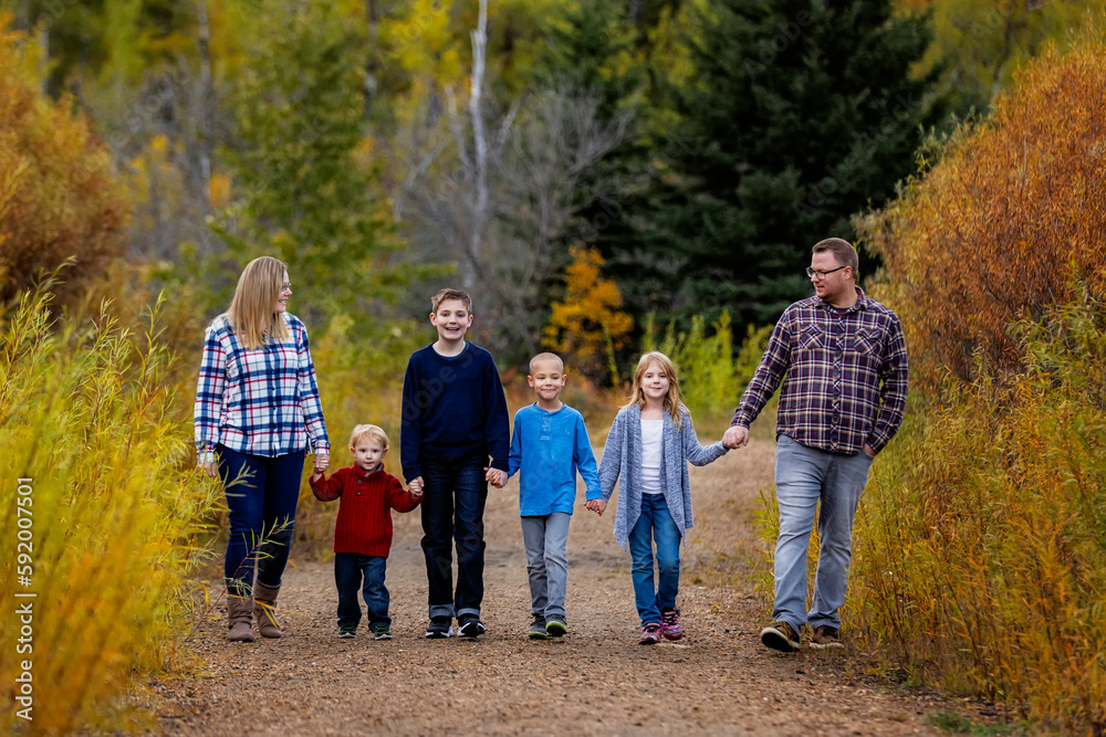 Family of six walking together hand in hand in a park in autumn; Edmonton, Alberta, Canada Family of six walking together hand in hand in a park in autumn; Edmonton, Alberta, Canada