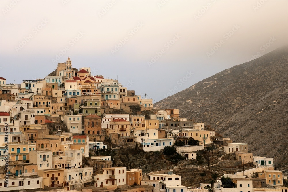 view of Olympos town with colourful buildings on Karpathos island, Greece with clouds descending onto the mountain