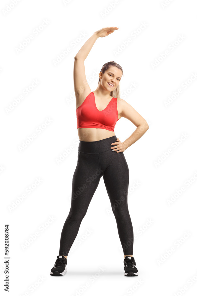 Full length pоrtrait of a young woman in sportswear stretching upper body Full length pоrtrait of a young woman in sportswear stretching upper body