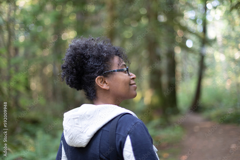 Woman outdoors enjoying nature as she smiles along a wooded trail in Stamp River Provincial Park; Port Alberni, British Columbia, Canada Woman outdoors enjoying nature as she smiles along a wooded trail in Stamp River Provincial Park; Port Alberni, British Columbia, Canada