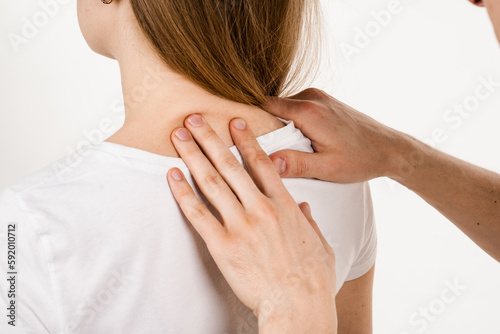 Orthopedic traumatologist examines head and neck of patient and checks mobility of movements on white background. Movement assessment or joint mobilization. Muscle release. photo