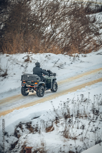 a rider on an ATV rides on a winter road © Иван Сомов