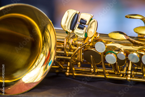 a fragment of a golden saxophone on a blurred background