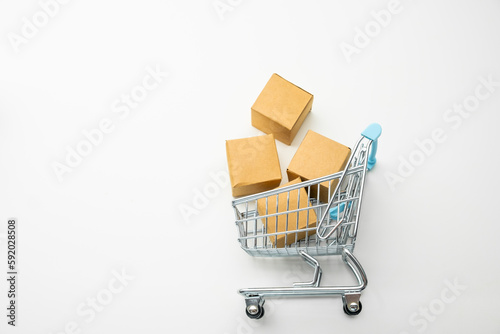 Top view of toy shopping cart with cardboard boxes on the white background with copy space. 