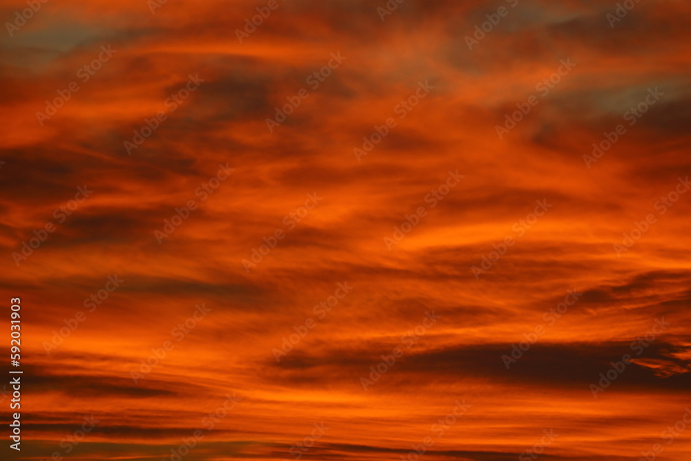 Blurry background of red   sunset sky. Dramatic sky with colorful cloud background. Red burning sunset sky.  Copy space.