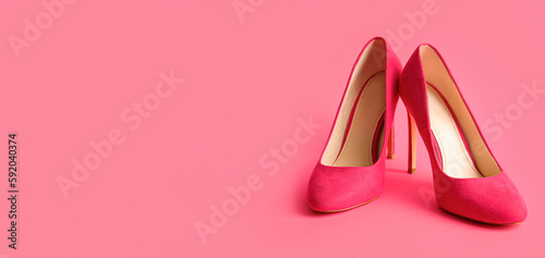 Pair of stylish high heeled shoes on pink background with space for text