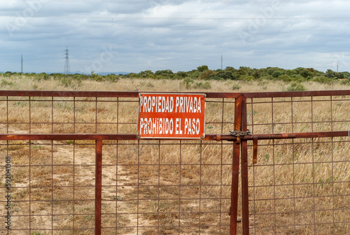 Portón de acceso a una finca con un letrero que prohíbe el acceso a una propiedad privada. Imagen horizontal. photo
