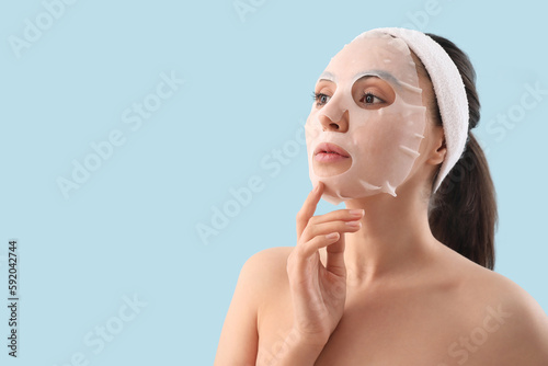 Young woman with sheet mask...