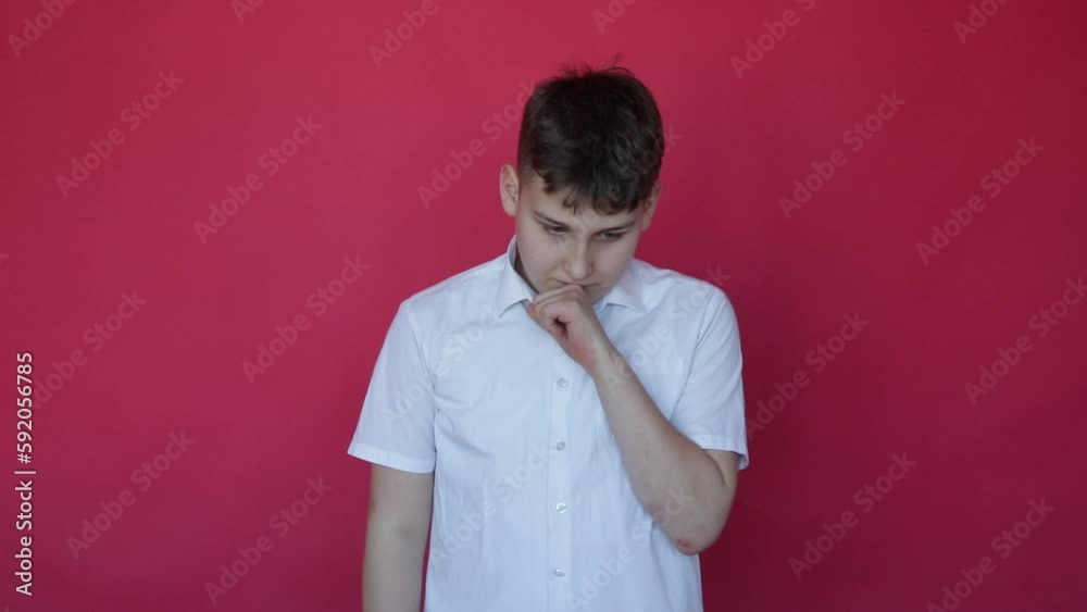 12-year-old boy shows with facial expressions and gestures that he has found solution to problem. Studio red background. 12-year-old boy shows with facial expressions and gestures that he has found solution to problem. Studio red background.