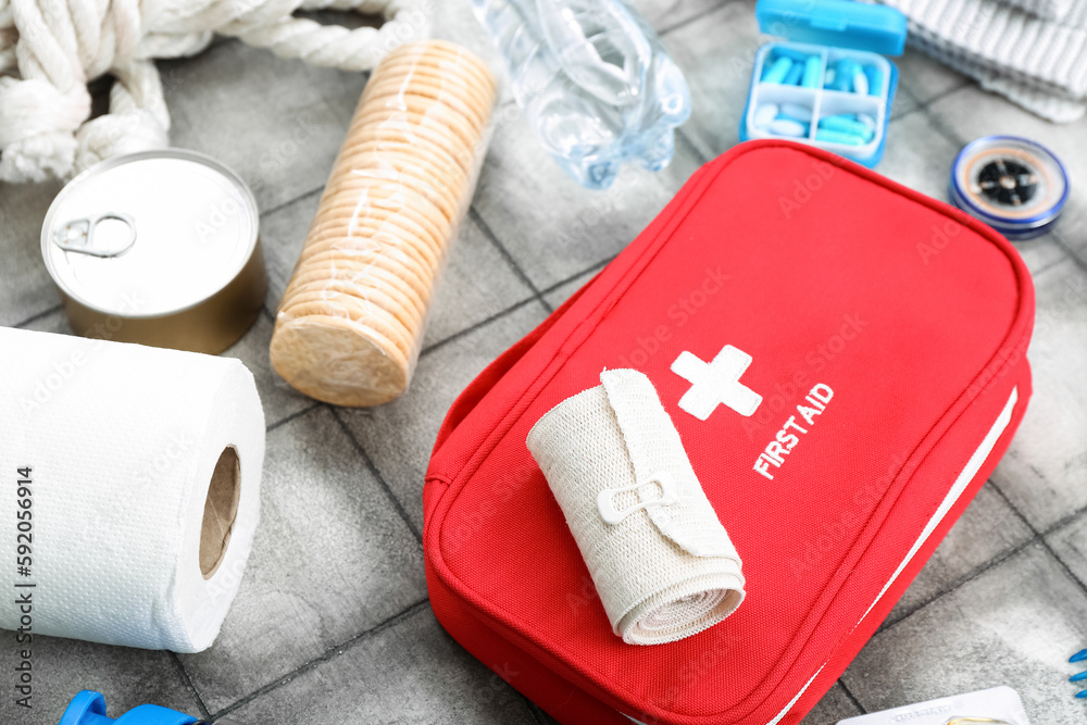 Fotografie Necessities for emergency bag on grey tile background, closeup