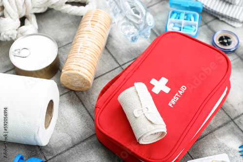 Necessities for emergency bag on grey tile background, closeup