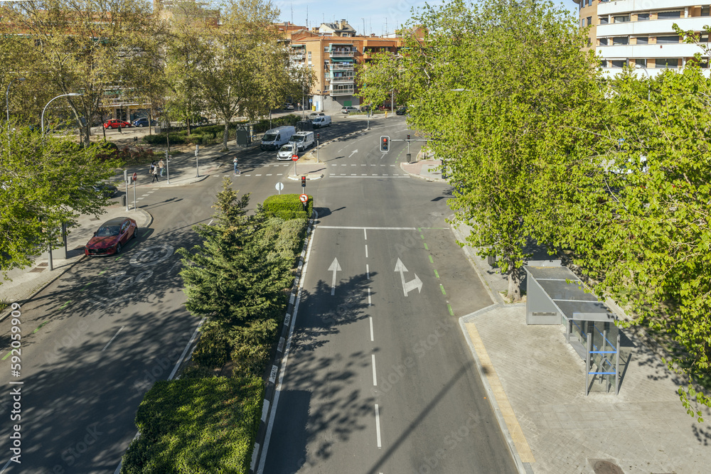 Ταπετσαρία A city street with a median lined with trees, hedges and plants and furniture fr