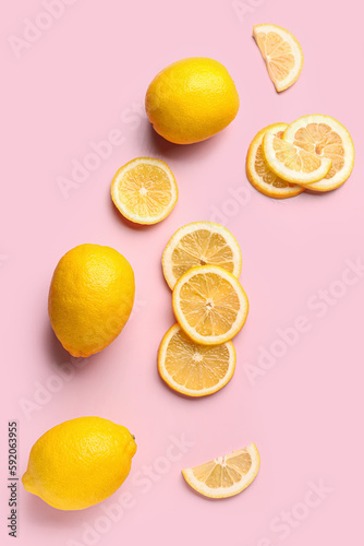 Composition with cut and whole fresh lemon on pink background