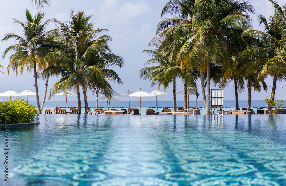 Swimming pool with patterned tiles in a hotel in the Maldives, on the backdrop of a tropical beach Swimming pool with patterned tiles in a hotel in the Maldives, on the backdrop of a tropical beach