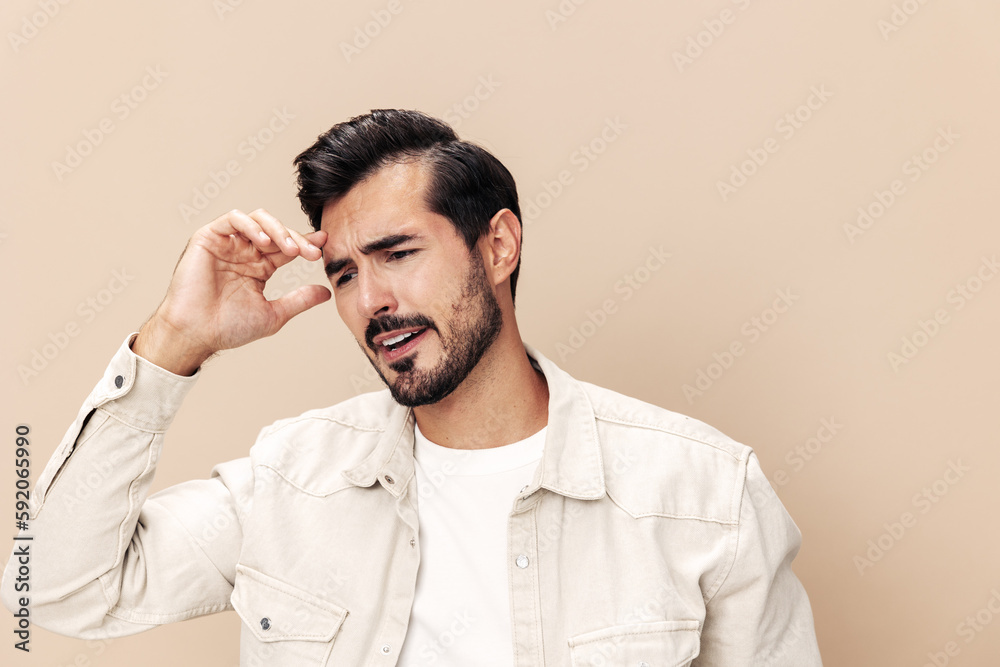Portrait of a stylish man dissatisfied and angry screaming on a beige background in a white t-shirt looking at the camera, fashionable clothing style, copy space, space for text Portrait of a stylish man dissatisfied and angry screaming on a beige background in a white t-shirt looking at the camera, fashionable clothing style, copy space, space for text
