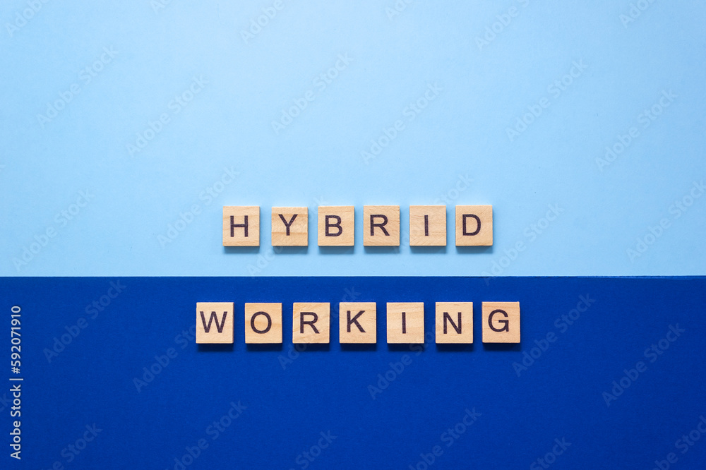 Words Hybrid working from wooden blocks with letters on a dark and light blue background. Selective focus, copy space Words Hybrid working from wooden blocks with letters on a dark and light blue background. Selective focus, copy space