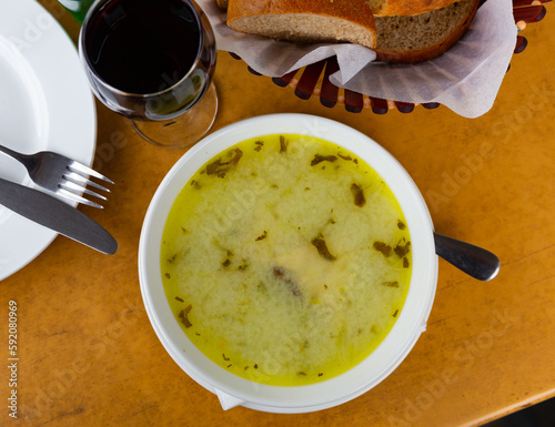 Traditional Georgian soup Chikhirtma from chicken and broth thickened with beaten eggs and flour served in white plate photo