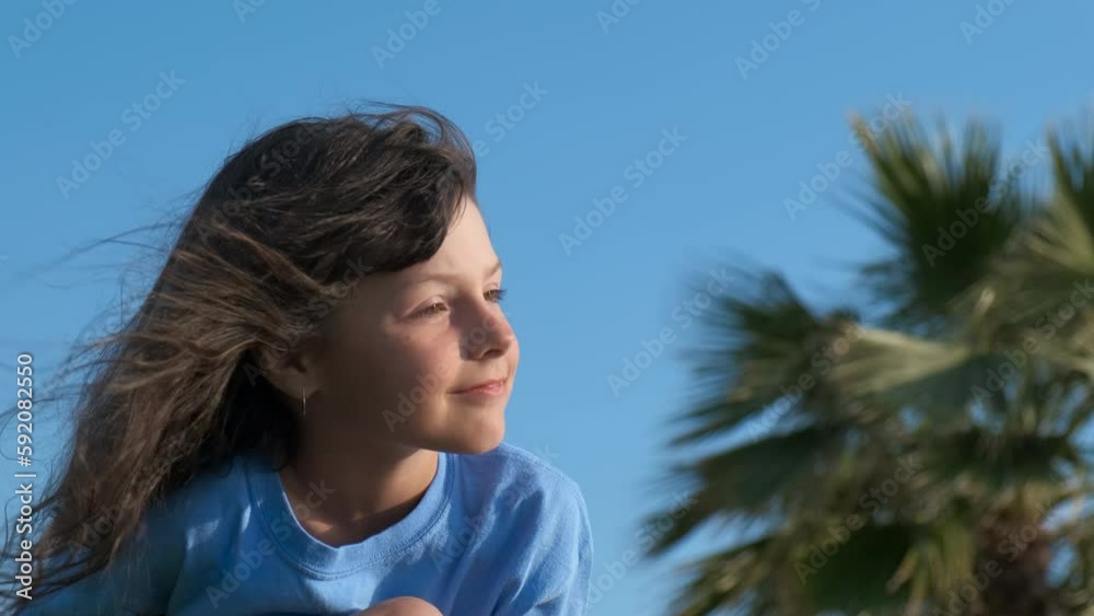 Happy child against palm beach. A smiling pretty little girl enjoy the wind in her hair during summer vacation. Happy child against palm beach. A smiling pretty little girl enjoy the wind in her hair during summer vacation.