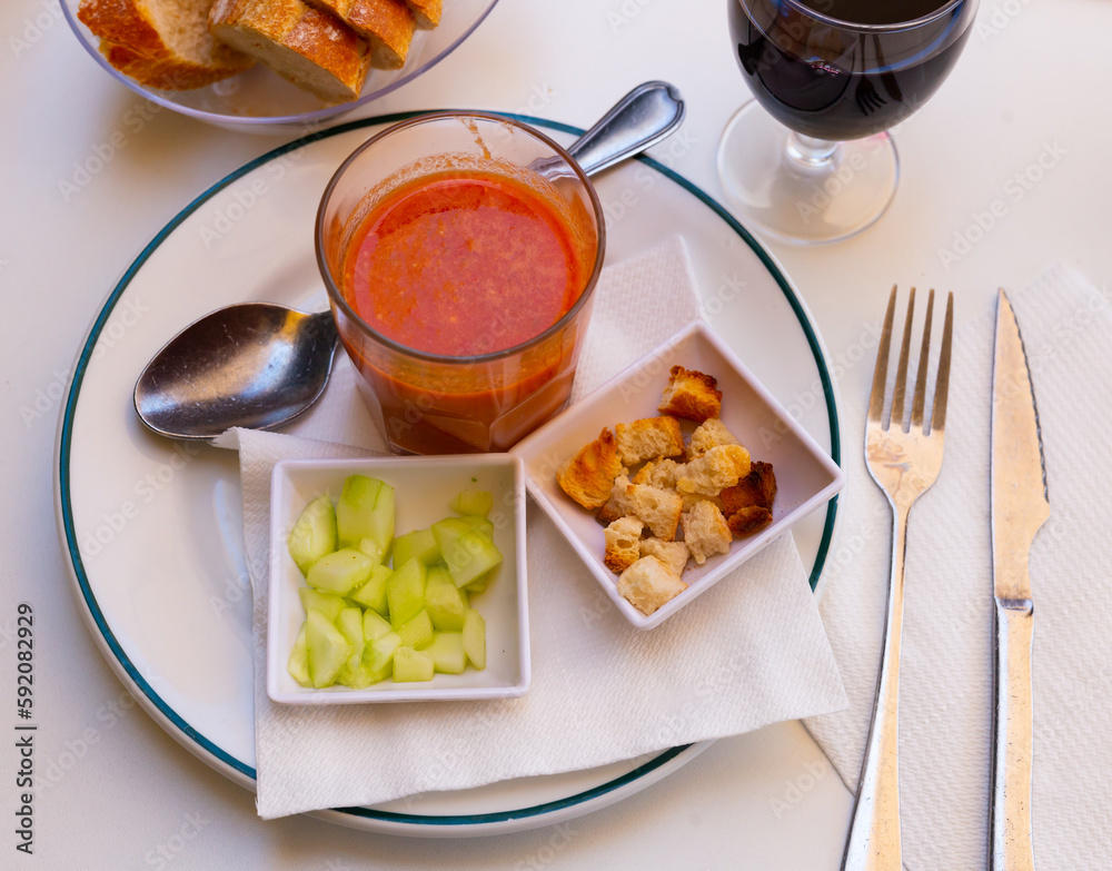 Gazpacho in glass spanish tomato based cold vegetable soup served with cucumbers and baked bread