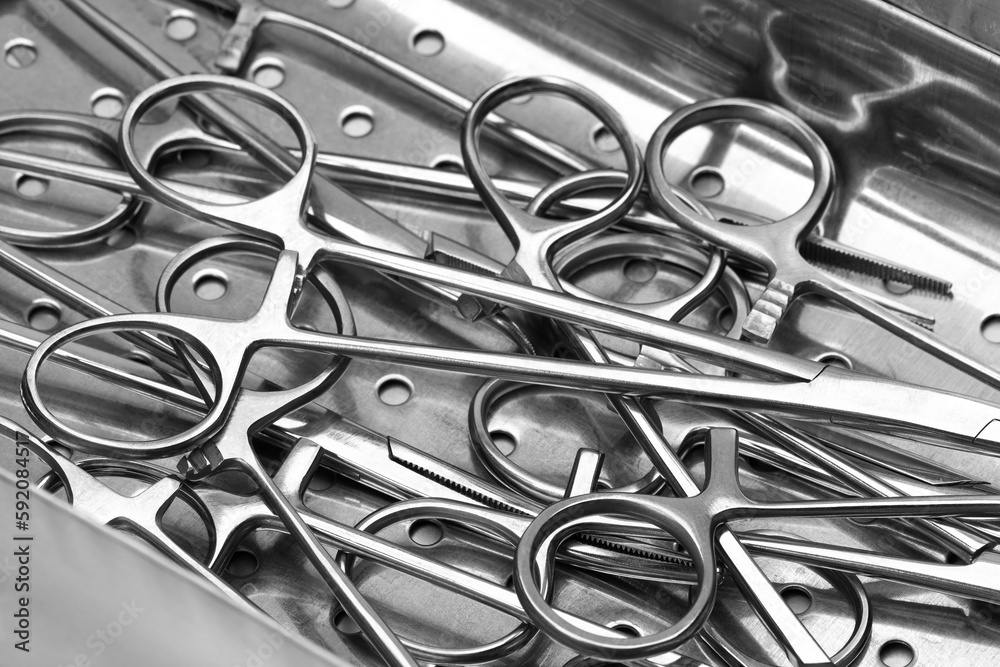 Closeup view of stainless surgical needle drivers lying down on steel