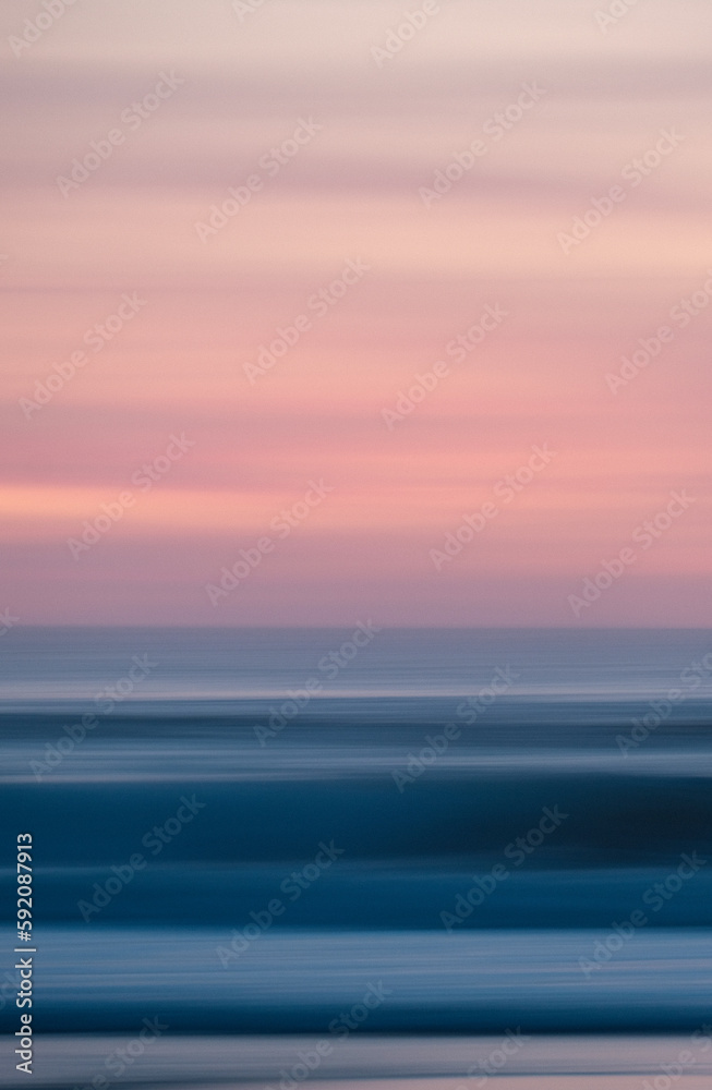 vertical motion blur photography of a beautiful sunset at the beach. mobile wallpaper