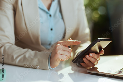 Modern accountant woman in green office using phone