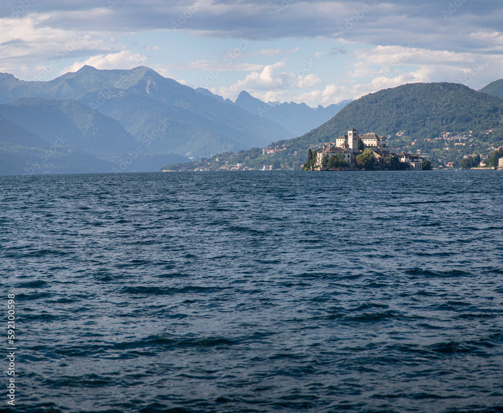 A lake Orta with a castle on St Julius Island and mountains in the background