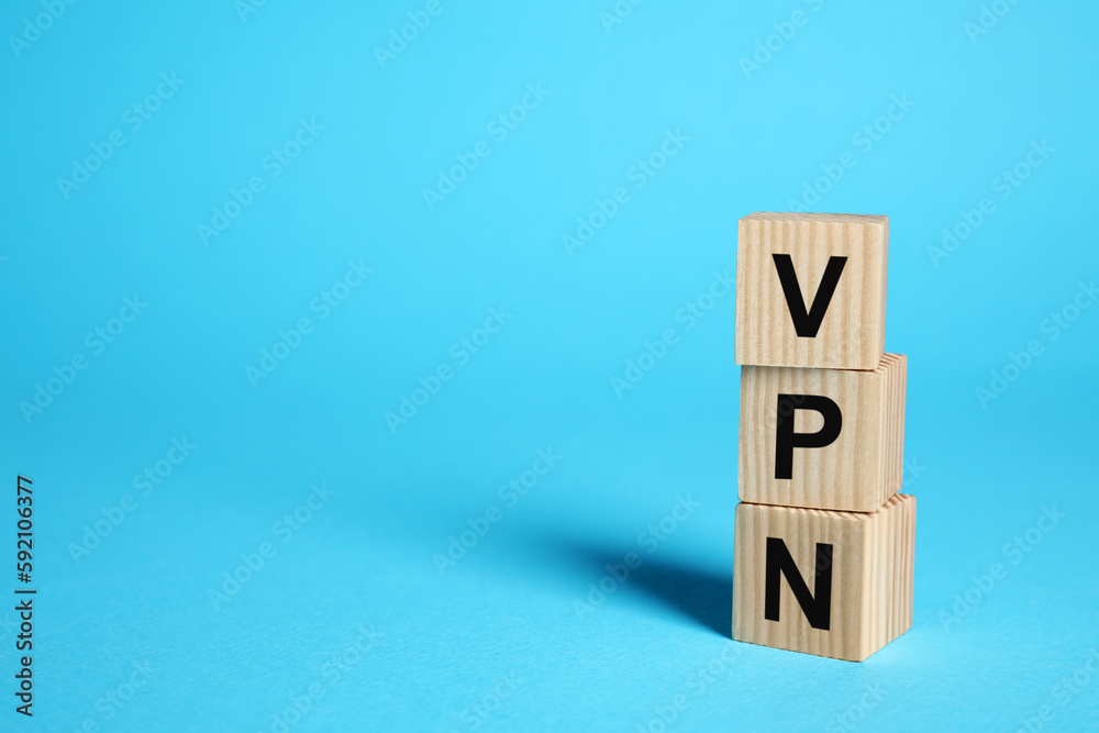 Wooden cubes with acronym VPN on light blue background, space for text Wooden cubes with acronym VPN on light blue background, space for text
