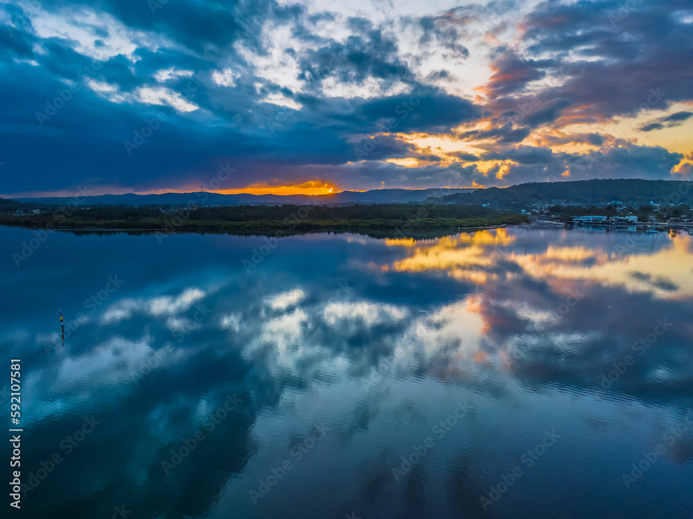 Sunrise waterscape with rain clouds and reflections