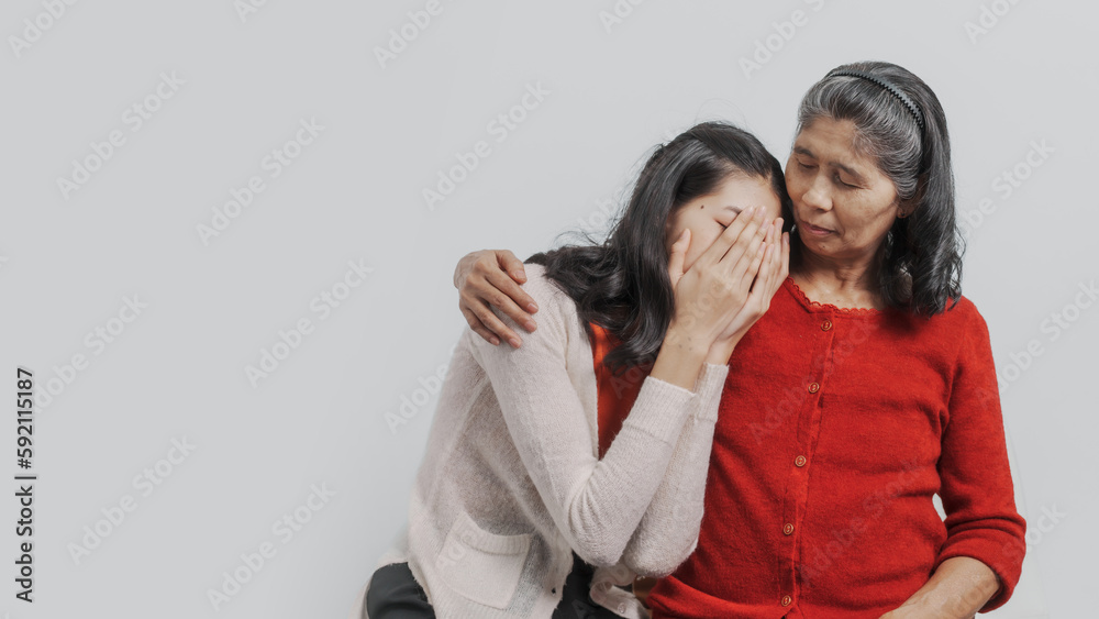 consolation, Senior mature asian woman with young daughter sitting together on couch, giving hug and love feeling happy, Mother day, birthday, family anniversary, love mom concept. consolation, Senior mature asian woman with young daughter sitting together on couch, giving hug and love feeling happy, Mother day, birthday, family anniversary, love mom concept.