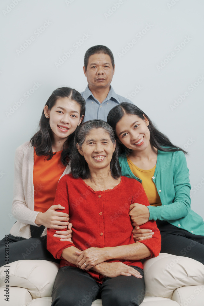 Looking camera, Happy anniversary day family of Elderly father and mother with old sister and young sister real people sitting together on sofa, Do activities together with love happily in the summer Looking camera, Happy anniversary day family of Elderly father and mother with old sister and young sister real people sitting together on sofa, Do activities together with love happily in the summer