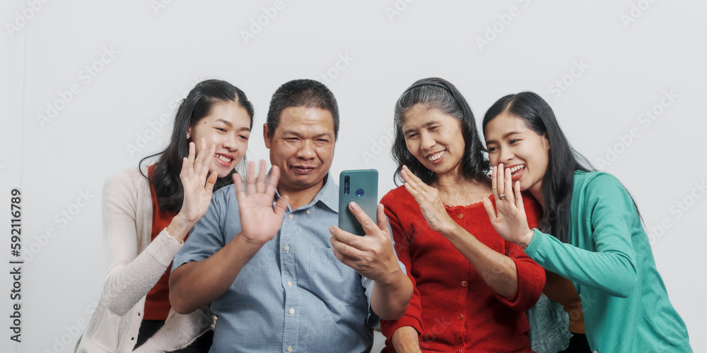 Mobile video call, Happy anniversary day family of Elderly father and mother with old sister and young sister real people sitting together on sofa, Do activities together with love happily summer Mobile video call, Happy anniversary day family of Elderly father and mother with old sister and young sister real people sitting together on sofa, Do activities together with love happily summer