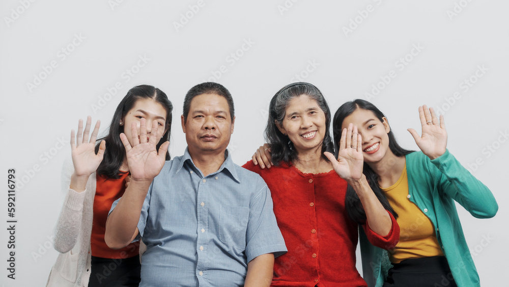 Hands wave, say hi, greeting, Happy anniversary day family of Elderly father and mother with old sister and young sister real people sitting together on sofa, Do activities together with love happily Hands wave, say hi, greeting, Happy anniversary day family of Elderly father and mother with old sister and young sister real people sitting together on sofa, Do activities together with love happily