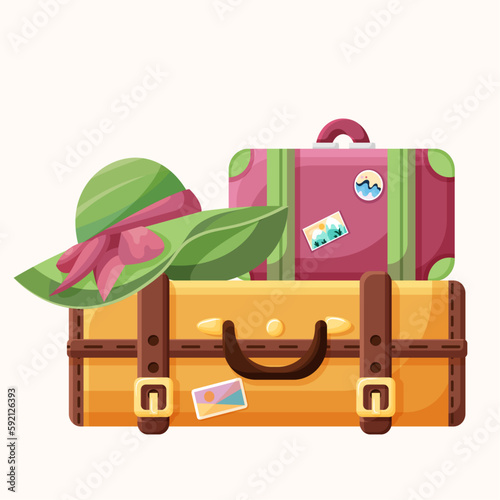 A big orange vintage suitcase and a small cute pink luggage with stickers and a big green women's summer hat. Elements for summer travel and vacation