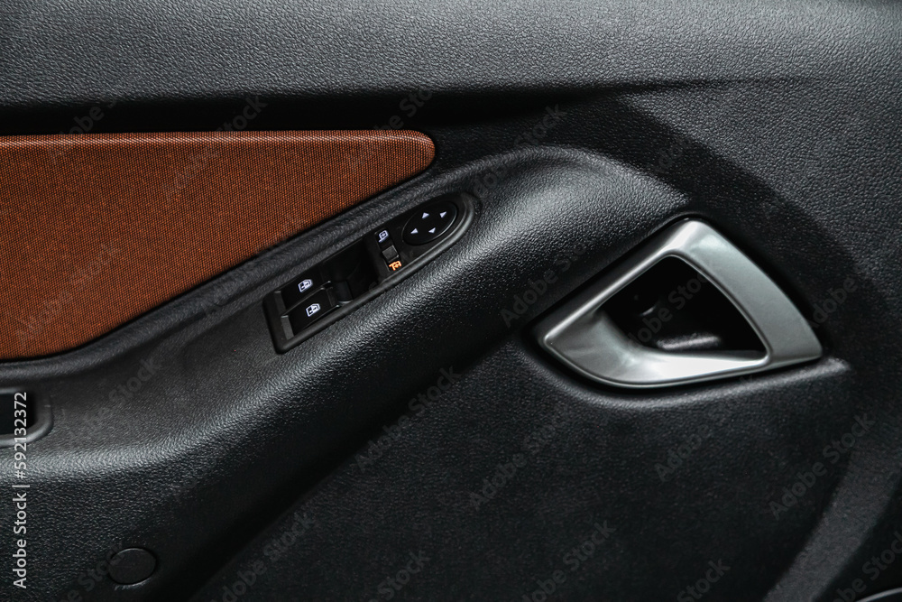 close-up of the side door buttons: window adjustment buttons, door lock. modern car interior: parts, buttons, knobs
