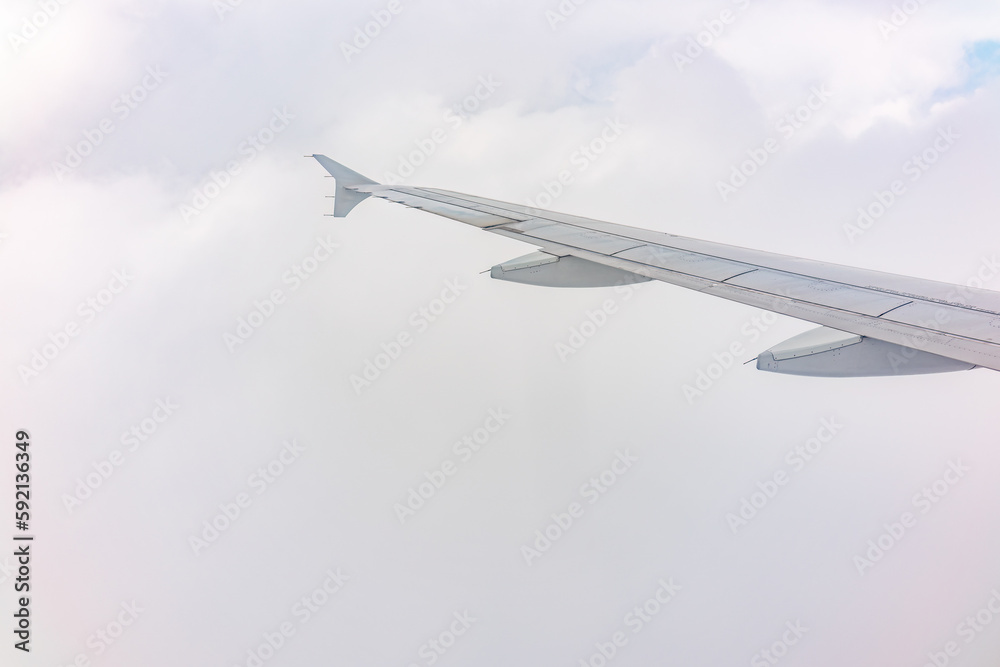 View from the airplane window at a beautiful cloudy sky and the airplane wing View from the airplane window at a beautiful cloudy sky and the airplane wing
