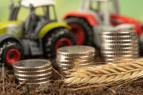 A small tractor in the garden with black soil. The concept of harvesting and making money on agriculture