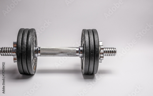 Iron dumbbell with pancakes on a white background. Sports with weights.