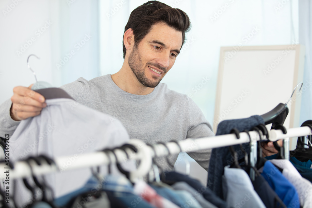 man choosing outfit in wardrobe man choosing outfit in wardrobe