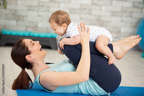 Photo mother makes postnatal exercises with her baby