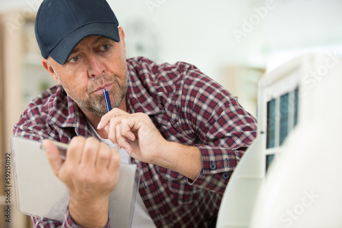 male technician checking appliance filter