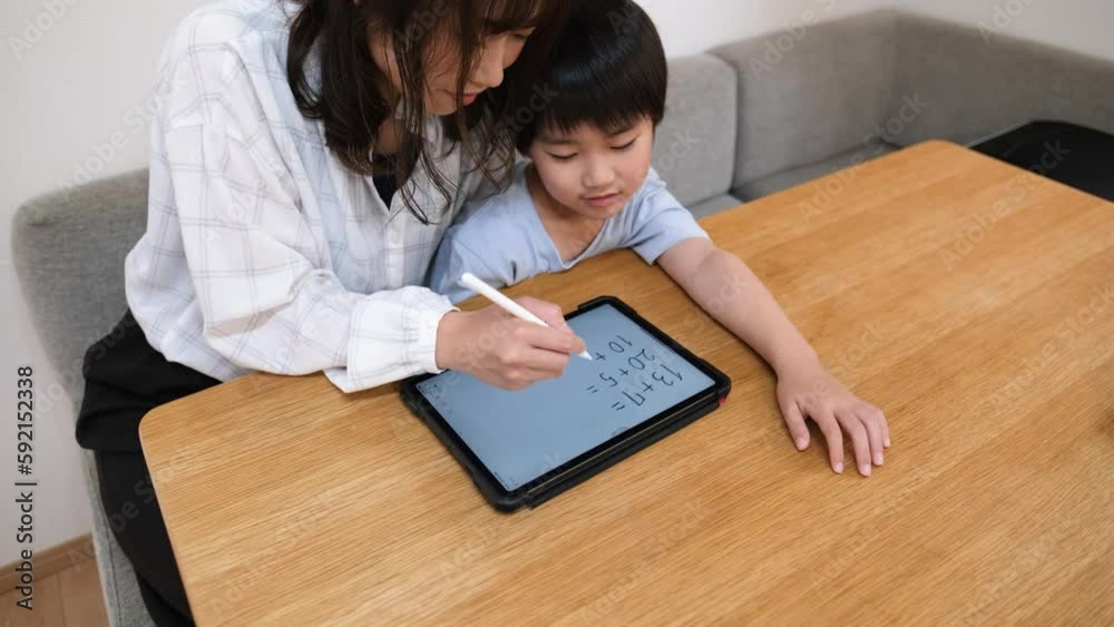 母親と一緒に家で勉強する小学生の男の子 母親と一緒に家で勉強する小学生の男の子