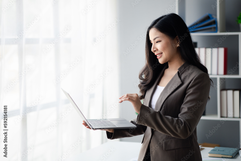 Business woman looking at data on laptop, young Asian women as executives, founding and running start-up executives, young female business leaders. Startup business concept. Business woman looking at data on laptop, young Asian women as executives, founding and running start-up executives, young female business leaders. Startup business concept.