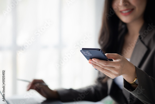 business woman using mobile phone to view data, young Asian women as executives, founding and running start-up executives, young female business leaders. Startup business concept.