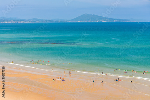 Canvas Print Surfers in the ocean at Cote des Basques beach in Biarritz, France on a summer d