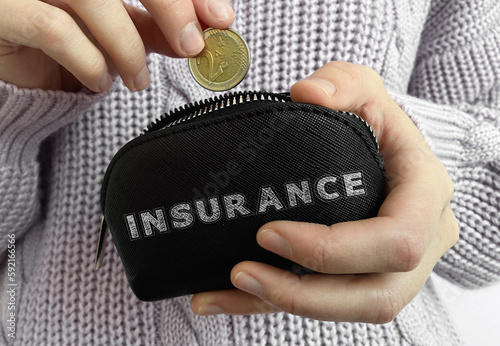 Woman's hand putting coin in black wallet with word Insurance